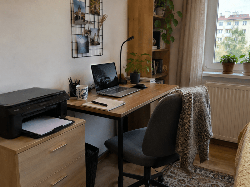 Birou de apartament cu laptop și imprimantă, într-un spațiu mic de lucru